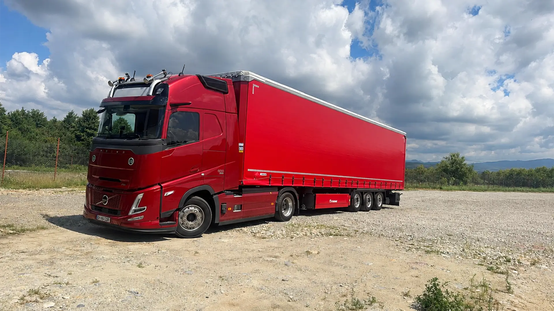 Cap tractor Volvo de ultima generatie si semiremorca mega cu prelata fotografiate in curtea companiei noastre