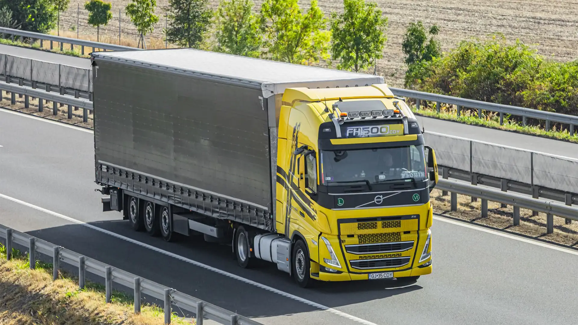 Un ansamblu cap tractor modern Volvo si o semiremorca mega cu prelata pentru transport marfuri international