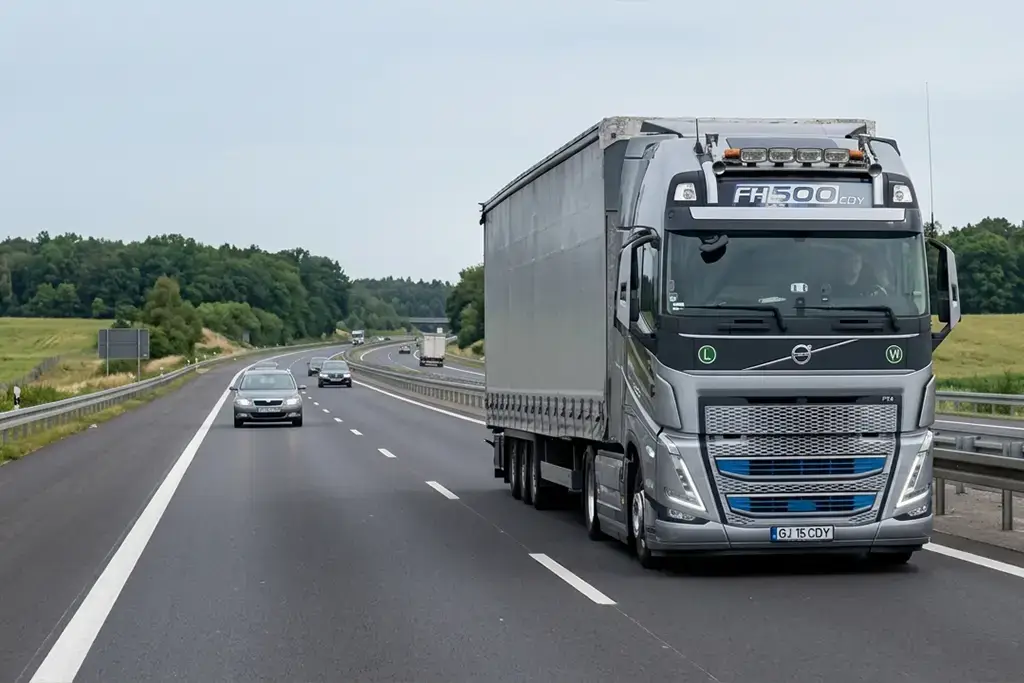 Camion Volvo modern si semiremorca mega cu prelata in mers pe autostrada